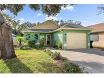 Single story home with light green exterior, attached garage, and landscaped yard at 3460 Reserve N Cir, St Petersburg, FL 33713