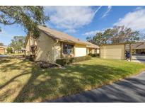 Exterior view of a single-story home with carport, landscaping, and a paved driveway at 2530 Oakleaf Ln # 31A, Clearwater, FL 33763