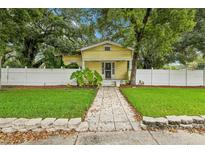 Cute yellow house with a front porch and a well-maintained lawn at 3210 N Tampa St, Tampa, FL 33603