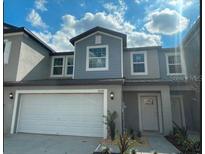 Charming townhome showcases a well-maintained lawn, two-car garage, and eye-catching architectural details at 36088 Joseph Blake St, Zephyrhills, FL 33541