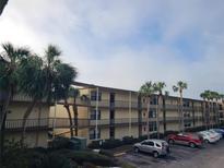 Two-story condo building with parking and tropical landscaping at 14130 Rosemary Ln # 6214, Largo, FL 33774