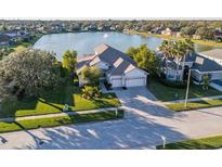 Aerial view of a single-Gathering home with a lake view and basketball court at 3115 Bowfin Dr, Land O Lakes, FL 34639
