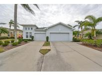 Two-car garage, light-blue exterior, landscaping at 2438 Sifield Greens Way # 44, Sun City Center, FL 33573