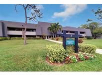 Exterior view of building with landscaping and signage at 36750 Us Highway 19 N # 20-205, Palm Harbor, FL 34684