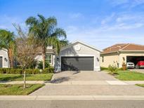 Two-car garage and attractive landscaping at 4719 Avila Lakes Dr, Wimauma, FL 33598