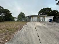 House exterior with driveway and yard at 6947 Bottle Brush Dr, Port Richey, FL 34668