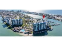 Aerial view of waterfront condo building with pool and marina at 9525 Blind Pass Rd # 507, St Pete Beach, FL 33706
