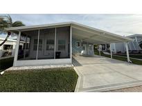 Single-wide home with carport and screened porch at 119 Dolphin S Dr, Oldsmar, FL 34677