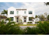 Two-story modern white house with dark gray doors and landscaping at 5980 Central Ave, New Port Richey, FL 34653