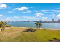Scenic waterfront view with palm trees and lush green grass at 8001 Sailboat Key S Blvd # 202, St Pete Beach, FL 33707