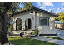 Updated bungalow with welcoming front porch, arched entry, and well-manicured lawn at 1206 E Osborne Ave, Tampa, FL 33603