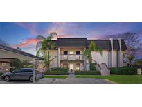 Attractive two-story condo building with lush landscaping and covered parking at 1401 Cordova Grn, Seminole, FL 33777