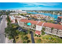 Aerial view of Bridge Hampton Bay condo complex, showing its location near the water and tennis courts at 8711 Blind Pass Rd # 307A, St Pete Beach, FL 33706