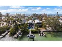 Aerial view of waterfront home with private dock and boat lifts, showcasing a desirable coastal location at 12112 Lagoon Ln, Treasure Island, FL 33706