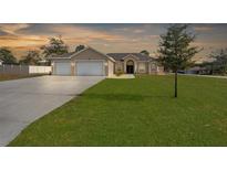 Single-story house with a two-car garage and a large front yard at 13254 Kitty Rd, Weeki Wachee, FL 34614