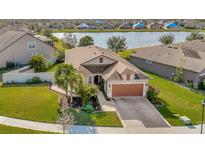 Single-Gathering home with a two-car garage and a landscaped yard, located on a quiet cul-de-sac at 16340 Treasure Point Dr, Wimauma, FL 33598