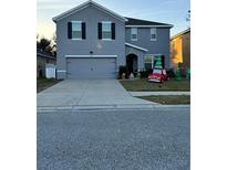 Two-story house with gray siding, two-car garage, and landscaped lawn at 451 Hartford Heights St, Spring Hill, FL 34609