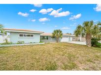 Ranch style home with palm trees and a spacious lawn at 12350 4Th E St, Treasure Island, FL 33706