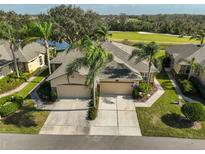 Exterior view of two-story house with double garage and landscaped yard at 2019 Acadia Greens Dr # 34, Sun City Center, FL 33573