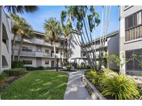 Exterior of condo building with lush landscaping and walkways at 2650 Countryside Blvd # C309, Clearwater, FL 33761