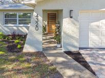Modern house exterior with landscaped walkway and updated garage at 4320 63Rd N St, Kenneth City, FL 33709