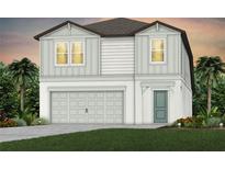 Two-story house with gray siding, two-car garage, and landscaping at 5309 Wolf Creek Dr, Apollo Beach, FL 33572