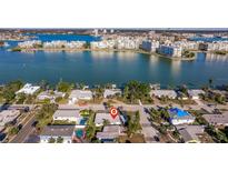 Aerial view showing home's location near water, surrounded by other houses at 8300 Boca Ciega Dr, St Pete Beach, FL 33706
