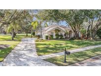Single-story home with landscaped yard and paved driveway at 1017 Royal Birkdale Dr, Tarpon Springs, FL 34688