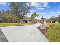 House exterior featuring a long driveway and landscaping at 4825 Scott Rd, Lutz, FL 33558