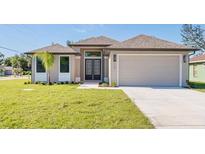 New construction home with a two-car garage and attractive landscaping at 112 Sidney Ct, Rotonda West, FL 33947