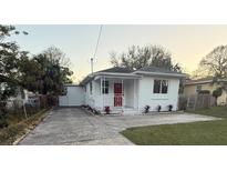 Charming single-story home featuring a bright red front door, white trim, and well-maintained landscaping at 1904 W Saint Louis St, Tampa, FL 33607