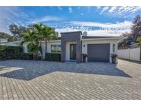 Stunning curb appeal with modern facade, paver driveway & tropical landscaping at 3312 W Swann Ave, Tampa, FL 33609