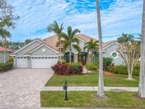 Stunning single-story home with a tile roof, three-car garage, and lush landscaping at 12113 Marblehead Dr, Tampa, FL 33626