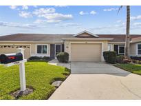 House exterior featuring a two-car garage and well-manicured lawn at 1709 Edgewater Ln, Palmetto, FL 34221