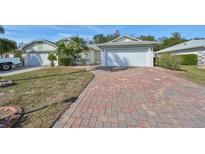 Two-story house with a brick driveway and attached garage at 1936 Grand Cypress Ln, Sun City Center, FL 33573