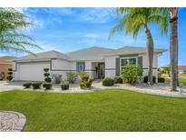 Single-story home with landscaped yard, two-car garage, and attractive curb appeal at 2357 Emerald Lake Dr, Sun City Center, FL 33573