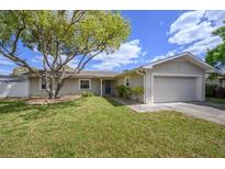 Single-story home with a landscaped lawn and attached garage at 3909 W Eden Roc Cir, Tampa, FL 33634