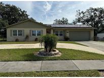 Single-story home with solar panels, driveway, and landscaped lawn at 529 Carriage Hills Dr, Temple Terrace, FL 33617