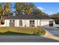 Newly renovated single-story home with a modern facade and attached garage at 18434 Goodman Cir, Port Charlotte, FL 33948