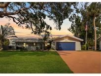 Charming ranch home with a spacious yard and updated blue garage door at 1985 Byram Dr, Clearwater, FL 33755