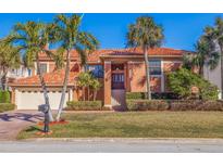 Two-story house with tile roof, attached garage, and manicured lawn at 207 8Th E St, St Petersburg, FL 33715