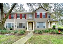 Tan two-story house with red shutters and a landscaped lawn at 2131 Golden Oak Ln, Valrico, FL 33594
