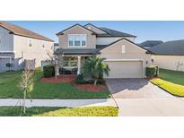 Two-story house with landscaped yard and two-car garage at 30868 Kelmin Ter, Wesley Chapel, FL 33543