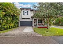 Two-story home with gray siding, a dark gray garage door, and a nicely landscaped front yard at 3608 W Horatio St, Tampa, FL 33609