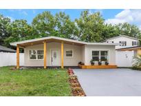 Newly renovated home with modern facade, covered porch, and landscaped lawn at 3909 W La Salle St, Tampa, FL 33607