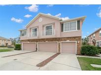 Tan three-unit townhome building with three-car garages, balconies, and landscaping at 504 51St N Ave, St Petersburg, FL 33703