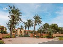 Gated community entrance of Hidden Lagoon, featuring palm trees and Mediterranean style buildings at 1695 Pinellas Bayway S # D1, Tierra Verde, FL 33715