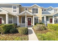 Two-story townhome with a red door and well-maintained landscaping at 3409 Santa Rita Ln, Land O Lakes, FL 34639