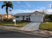 Single-story home with attached garage, driveway, and landscaped lawn at 4415 Great Lakes N Dr, Clearwater, FL 33762