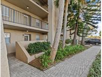 Exterior view of condo building with landscaped walkway and parking at 90 S Highland Ave # 102, Tarpon Springs, FL 34689